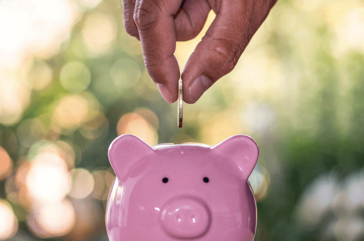 putting coin in piggybank